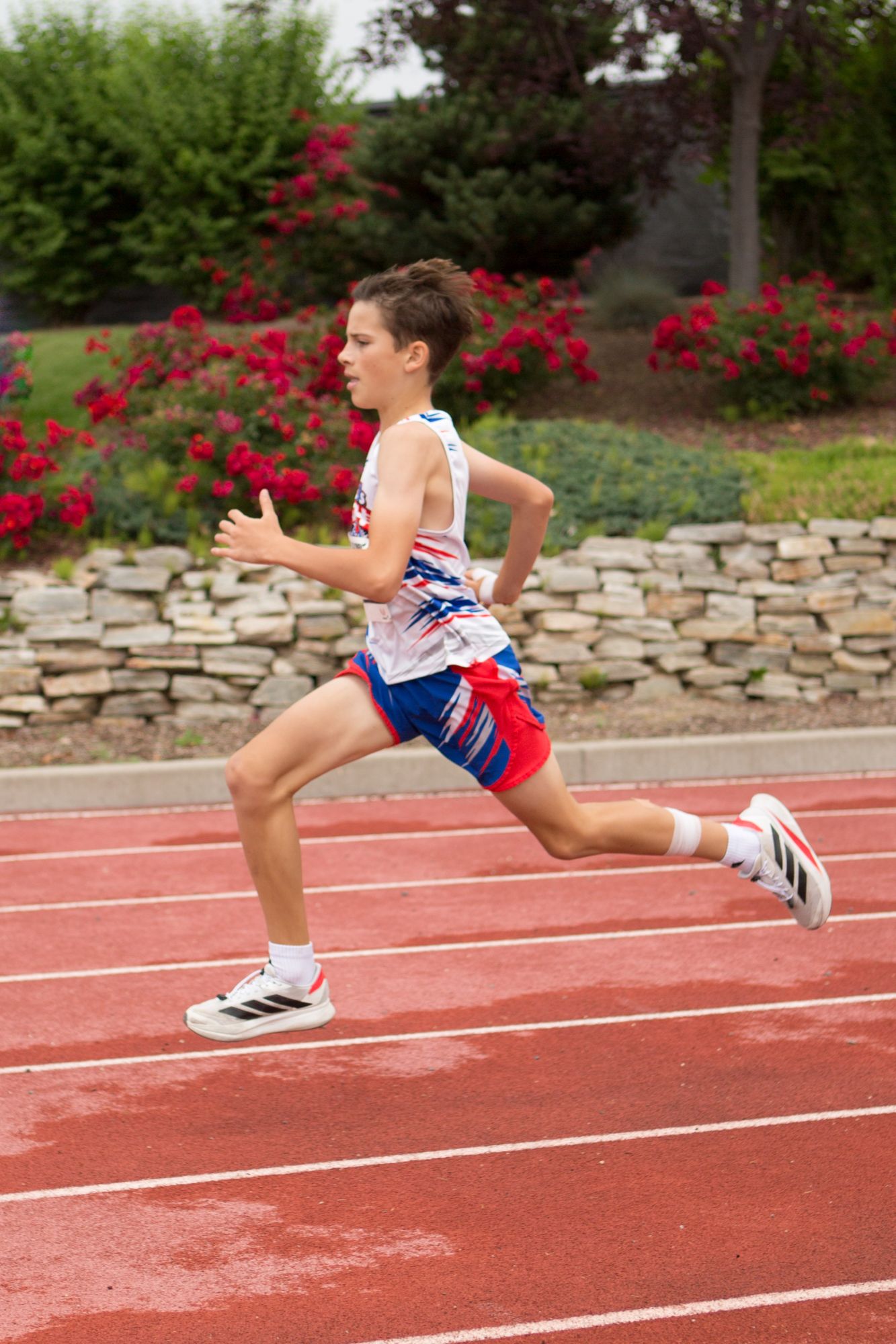 A DASH runner sprinting past a rose garden in his team singlet